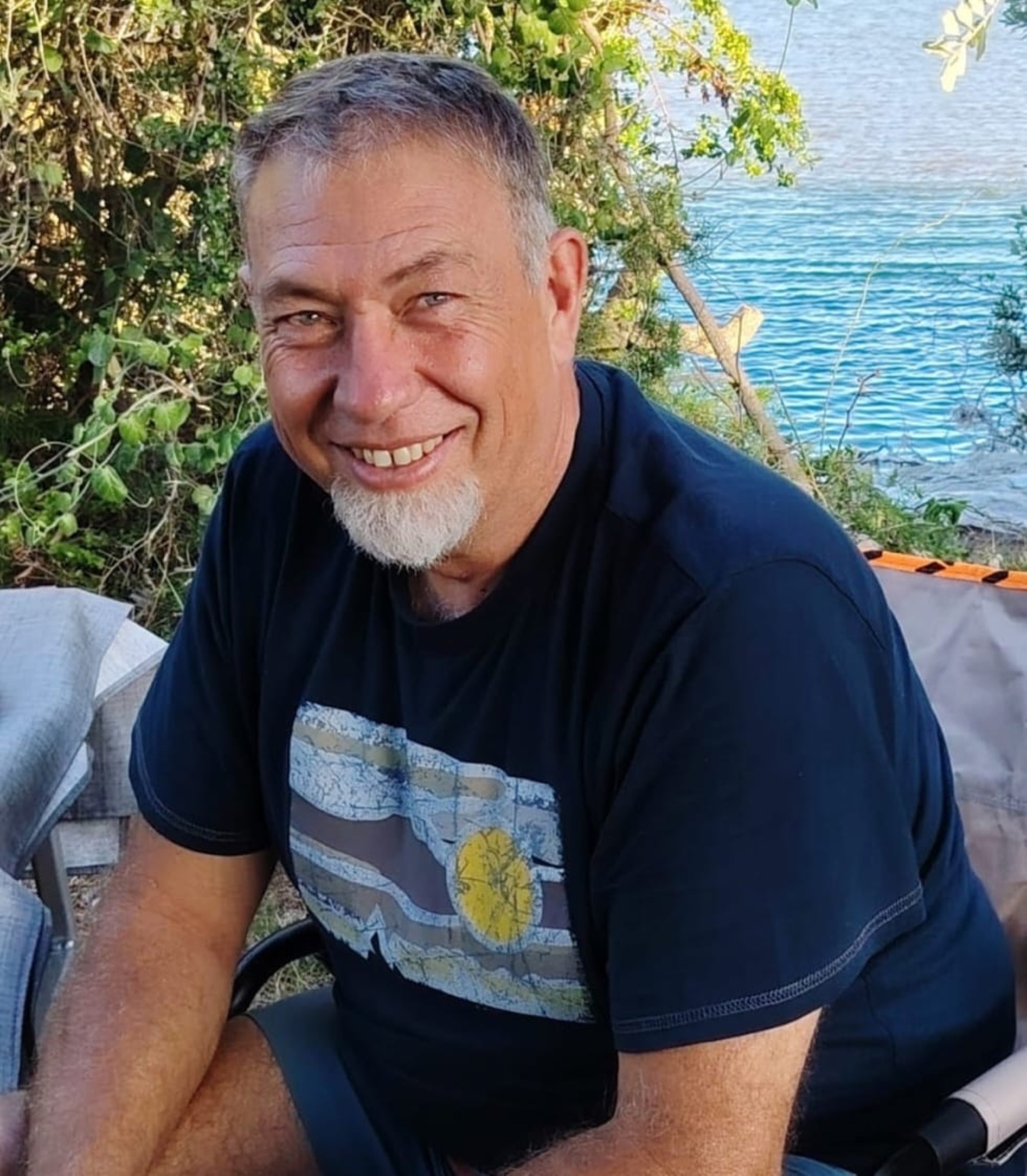 Gerhardt smiling beside the water